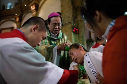 El obispo Joseph Li Shan bautiza a una mujer en la catedral de la Inmaculada Concepción, este sábado en Pekín.