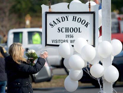 Andrea Jaeger lleva flores y una vela en el exterior de la escuela Sandy Hook, en Newtown.