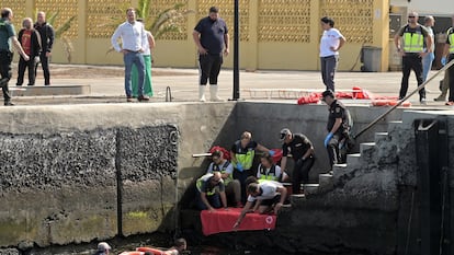 Agentes de Policía Nacional rescatan a uno de los migrantes que viajaba en el cayuco que ha volcado a su llegada al puerto de La Restinga, este miércoles.