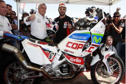 El presidente de Chile, Sebastián Piñera, junto a <i>Chaleco</i> López y la moto del piloto.