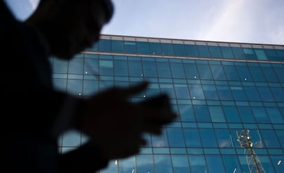 Un usuario maneja su teléfono móvil en una zona empresarial.