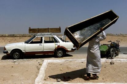 Un hombre transporta un ataúd tras el funeral de una madre y de una hija muertas en un atentado con coche-bomba en una mezquita iraquí, en el que fueron asesinadas más de 80 personas en Najaf, Irak. Agosto de 2003.