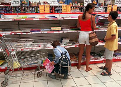 Varias personas compran libros de texto en una gran superficie de Madrid.