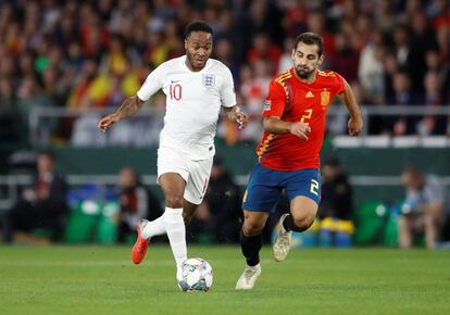 El jugador de la selección inglesa, Raheem Sterling, corre con el balón ante la presencia del jugador del combinado español, Jonny Castro.