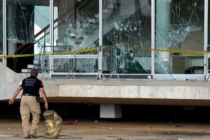 An agent walks past the head of a statue depicting the Greek goddess Themis, outside the Brazilian Supreme Court building that was damaged by supporters of Brazil's former President Jair Bolsonaro, in Brasilia, Brazil, Tuesday, Jan. 10, 2023.