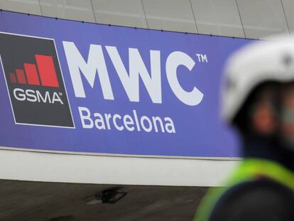 Trabajador del Mobile World Congress de Barcelona junto a un cartel del evento cancelado por el coronavirus