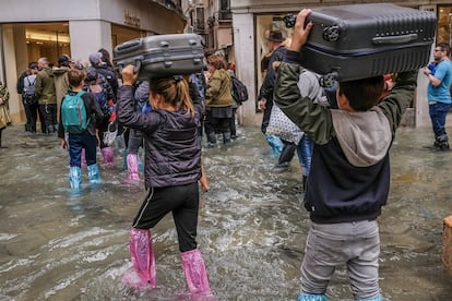 Os turistas cruzam as ruas de Veneza com a bagagem sobre suas cabeças e com protetores plásticos até os joelhos para tentar não se molhar. Em algumas zonas da cidade, a água alcançou 156 centímetros sobre o solo.