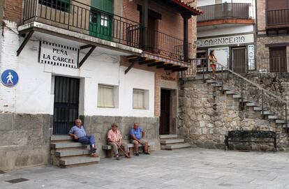 Varias personas descansan en la plaza principal de Santa Cruz del Valle, el pueblo mas endeudado de España por habitante.