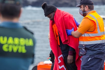 Uno de los migrantes recibe la ayuda de un trabajador de protección civil. La situación también ha llevado a Cruz Roja a reforzar sus medios. "Ha sido bastante complejo, pero Cruz Roja Española está capacitada para atender a estos y al doble, si llegan. Estamos bien y atenderemos a cuantos lleguen, porque es nuestra misión", ha señalado el vicepresidente de la entidad en las islas.