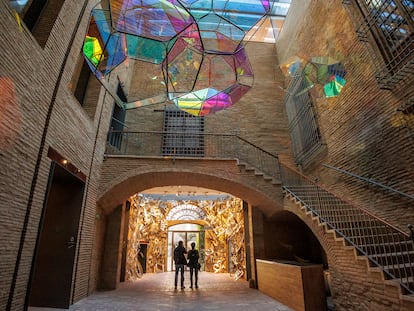 El vestíbulo del Centro de Arte Hortensia Herrero, en el antiguo Palacio Valeriola de Valencia, con obras de Tomás Serraceno, en primer plano, que simulan nubes iridiscentes, y la instalación de Jaume Plensa 'Melic', con letras de alfabetos de todo el mundo.