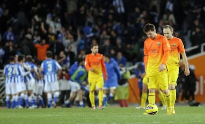 Barcelona's Lionel Messi (2nd R) and Barcelona's midfielder Andrés Iniesta (R) react after Real Sociedad scored its third goal.