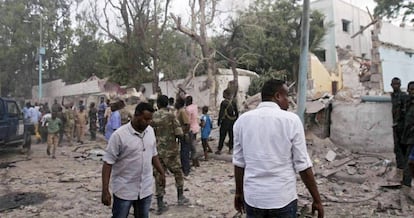 Fuerzas de seguridad y civiles, en el lugar de la explosi&oacute;n de uno de los coches bomba que han explotado este s&aacute;bado en Mogadiscio.