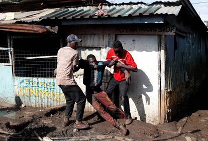 Dos opositores sostienen a un manifestante herido durante enfrentamientos con la policía en Kibera, a las afueras de la capital.