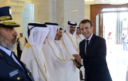 El presidente francés, Emmanuel Macron (d) saluda a oficiales cataríes durante una reunión este jueves en Doha.