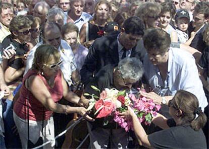 Asunción Balaguer besa la urna con las cenizas de Paco Rabal, que sujetan sus hijos Benito y Teresa Rabal, ayer durante su entierro.