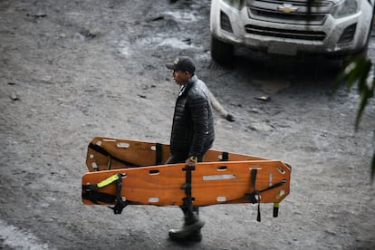 Un hombre camina con dos camillas para transportar heridos mientras continúan las labores de rescate, este miércoles por la tarde.