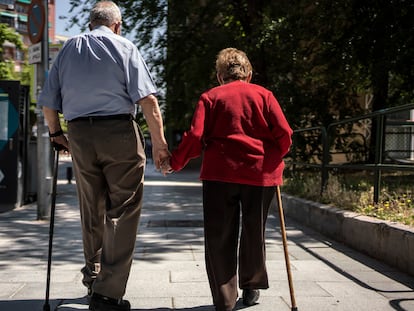 Un hombre y una mujer mayores caminan por la calle Caramuel, en el barrio de Puerta del Angel, Madrid.