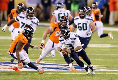 Russell Wilson, quarterback de Seattle, tenta se safar da defesa de Denver