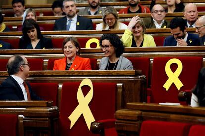 La presidenta del Parlament, Carmen Forcadell (i), y la secretaria general de ERC, Marta Rovira (d), rodeadas por varios escaños vacíos adornados con lazos amarillos en recuerdo de los diputados electos encarcelados y huidos en Bruselas, poco antes del comienzo del pleno de constitución para dar inicio a la XII legislatura.