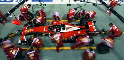 Mecánicos de Ferrari cambian neumáticos en una carrera de F1.