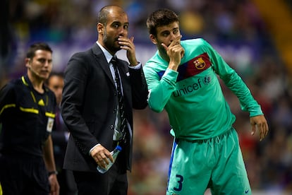 El entrenador del Barça, Josep Guardiola (a la izquierda), da instrucciones a Piqué durante un partido de la Liga, en 2011.