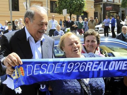 Carlos Slim posa con un bufanda del Oviedo y una aficionada, este viernes.