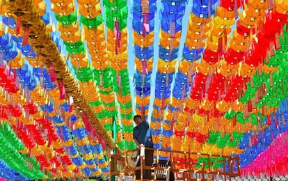 Un trabajador de Corea del Sur coloca tarjetas con deseos de los seguidores budistas entre farolillos de loto con motivo del cumpleaños de Buda en el templo Jogye en Seúl.