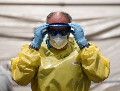 Un enfermero se coloca sus gafas de protección, durante el acondicionamiento de varios pabellones de Ifema como hospital provisional.