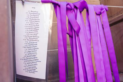 Lienzos morados por cada víctima de homicidio de este año, junto a los nombres, afuera de la Iglesia First and Franklin.