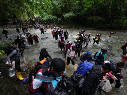 Migrants cross a river in the Darién jungle to reach Panama, on October 15, 2022.