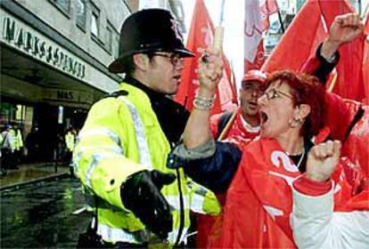 Un grupo de manifestantes discuten con un policía ayer frente a una tienda de M&S en Londres.