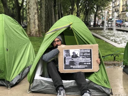 Micky en su tienda de campaña enseña uno de sus carteles de protesta.