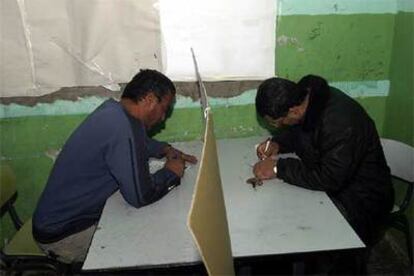 Dos palestinos votan en un colegio electoral de Yenín.