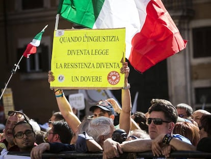 Un activista muestra la pancarta &quot;Cuando la injusticia se convierte en ley, la resistencia se convierte en un deber&quot; durante una manifestaci&oacute;n, convocada por el Movimiento 5 Estrellas este mi&eacute;rcoles. 