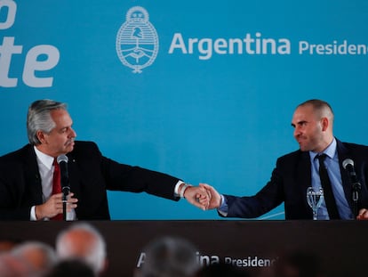 El presidente de Argentina, Alberto Fernández (izquierda), saluda al ministro de Economía, Martín Guzmán, durante el anuncio de la creación de un impuesto sobre las llamadas "ganancias extraordinarias", el 6 de junio de 2022 en Buenos Aires.