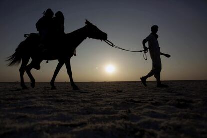 Unos turistas disfrutan de un paseo a caballo en la arena del desierto de Thar, también conocido como el gran desierto indio, situado al noroeste de la India, 9 de enero de 2014.