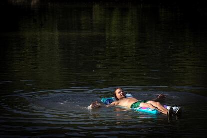 Un hombre se refresca en el río Arga a su paso por Pamplona. 