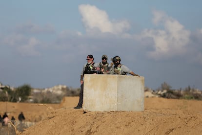 Un guardia de seguridad extranjero observa cómo los palestinos que fueron desplazados regresan a sus casas en el norte de Gaza.