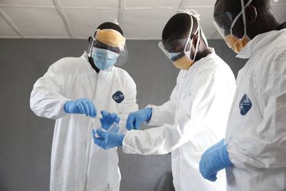 Tres médicos tratan de averiguar la causa de muerte de una mujer en Liberia.