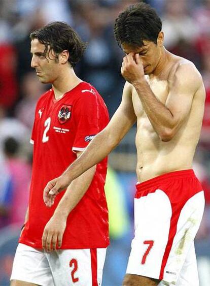 Los jugadores austriacos Ivica Vastic y Joachim Standfest abandonan el campo tras perder ante Croacia