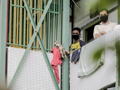 Varios trabajadores protegidos con mascarilla se asoman en un edificio de apartamentos humilde en Singapur, 28 de abril de 2020. La mayoría de los contagiados confirmados de coronavirus en esta ciudad-Estado son inmigrantes que viven en este tipo de edificios, generalmente hacinados y con condiciones higiénicas deficientes.