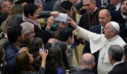 El papa Francisco recibe una carta de una mujer durante la audiencia general de los miércoles.