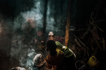 Algunos de los hijos de Balança Manuel Sande y su esposa Zeira asan maíz en la cocina de su cabaña, en el barrio 24 de Julho de Mopeia, en Mozambique. Se trata de un área rural con elevados índices de pobreza.