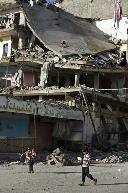 Unos niños, durante las cinco horas de alto el fuego, frente a un edificio destruido durante una ofensiva militar.