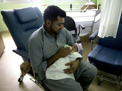 Un padre pakistaní da este martes el biberón a su bebé recién nacido en San Sebastián.