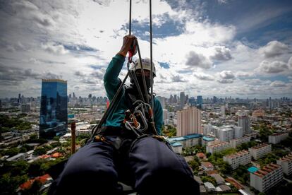 Un operario trabaja en la limpieza de cristales de un rascacielos de Bangkok. Tailandia se encuentra en la tercera fase de medidas de confinamiento por el coronavirus, reabriendo la mayoría de las empresas para reiniciar gradualmente la economía.