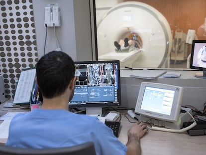 Un profesional sanitario realiza una resonancia magnética a una persona en un hospital de Francia.