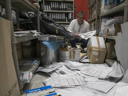 Cristóbal López hojea varios de los expedientes de pacientes que se hallan esparcidos por el suelo de la nave.