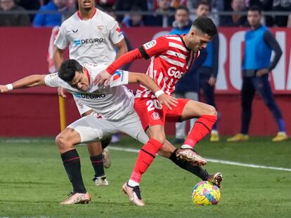 GIRONA, 14/01/2023.- El lateral derecho del Girona FC Yan Couto (d), disputa el balón con el defensa del Sevilla FC, Marcos Acuña (i) durante el partido de LaLiga Santander entre el Girona FC y el Sevilla FC celebrado este sábado en el estadio municipal de Montilivi, en Girona. EFE/ David Borrat
