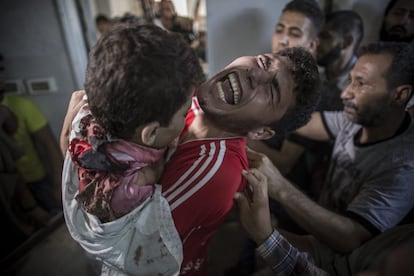 Un hombre palestino llora mientras sujeta el cuerpo sin vida de su hermano pequeño que ha muerto en un bombardeo israelí en el puerto de Gaza, en el depósito de cadáveres del hospital Shifa. Cuatro niños palestinos murieron en un ataque aéreo israelí en la franja de Gaza, que hirió a otra decena de menores, informó el portavoz del Ministerio de Sanidad, Ashraf Al Qedra.